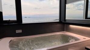A bathtub with a view of the sea through large windows. - Hashimotoya (Himi)