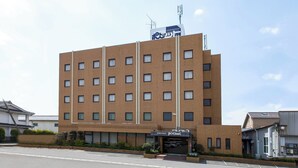 Um hotel de vários andares com fachada de tijolos, várias janelas e uma placa indicando hotel executivo.