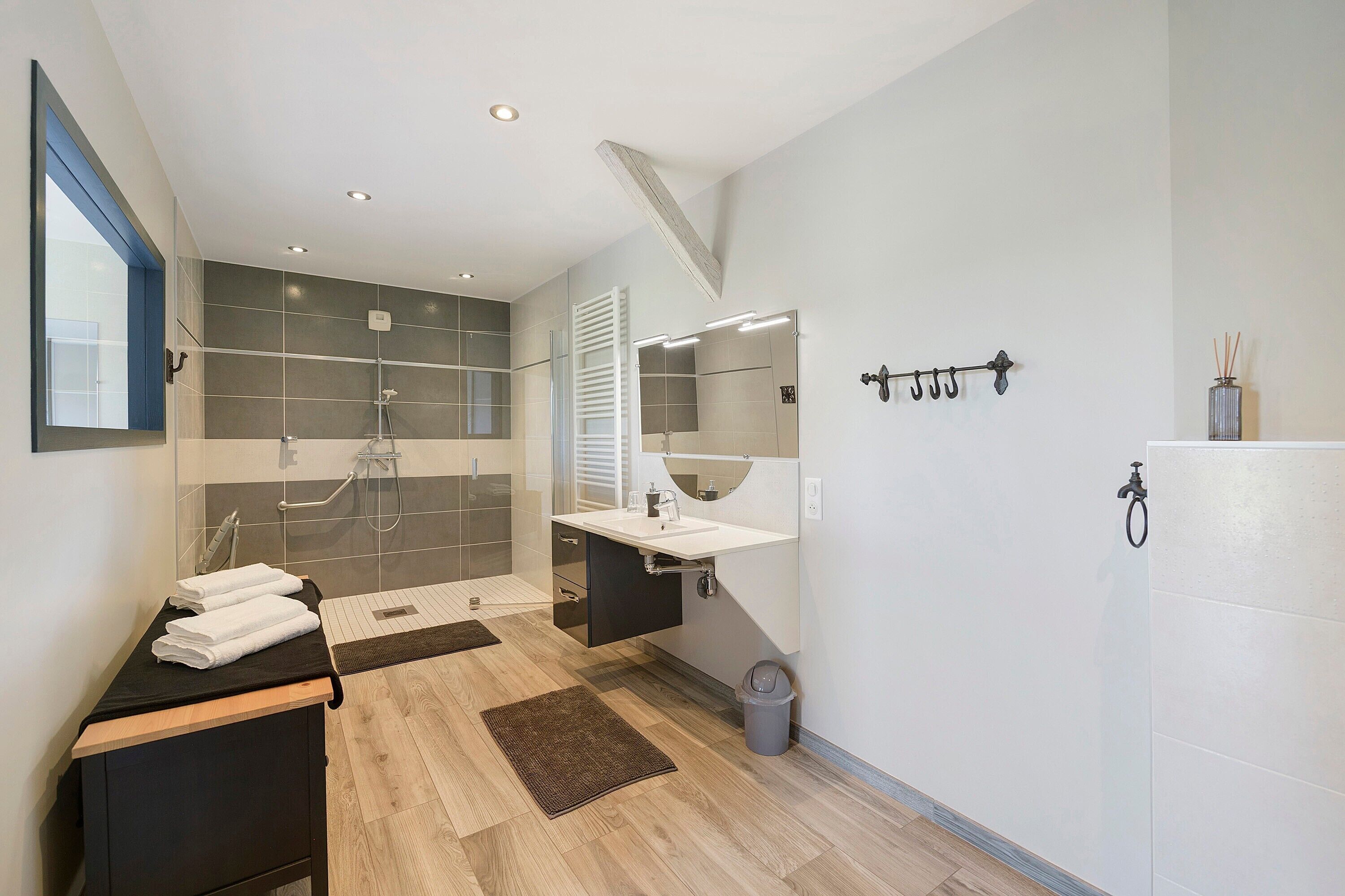 A modern bathroom with a shower, sink, and mirror.