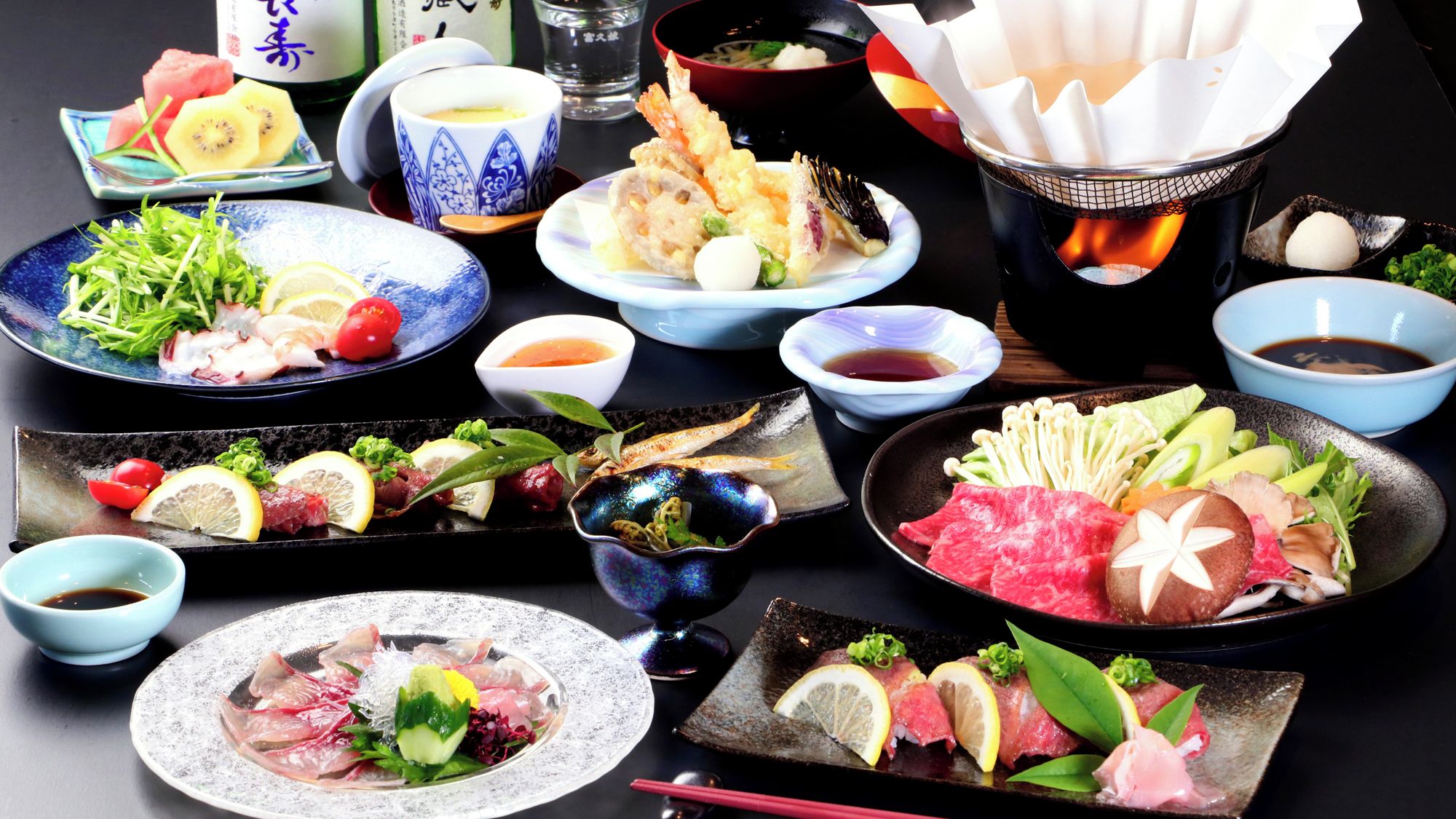 Variedad de platos japoneses, como sashimi, tempura y una preparación para hot pot.