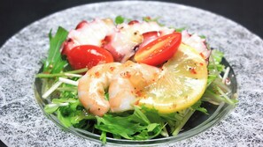 A salad with shrimp, tomatoes, and lemon slices on a plate. - Ryori Ryokan Marumo (Takashima)