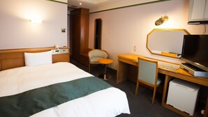 A hotel room with a bed, a desk, a chair, a television, and a minibar. - Hotel New Global (Isahaya)