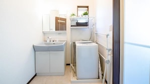 A compact bathroom with a sink, mirror, and a small refrigerator. - Fuji Viewest Villa Rakuwa (Fujikawaguchiko)