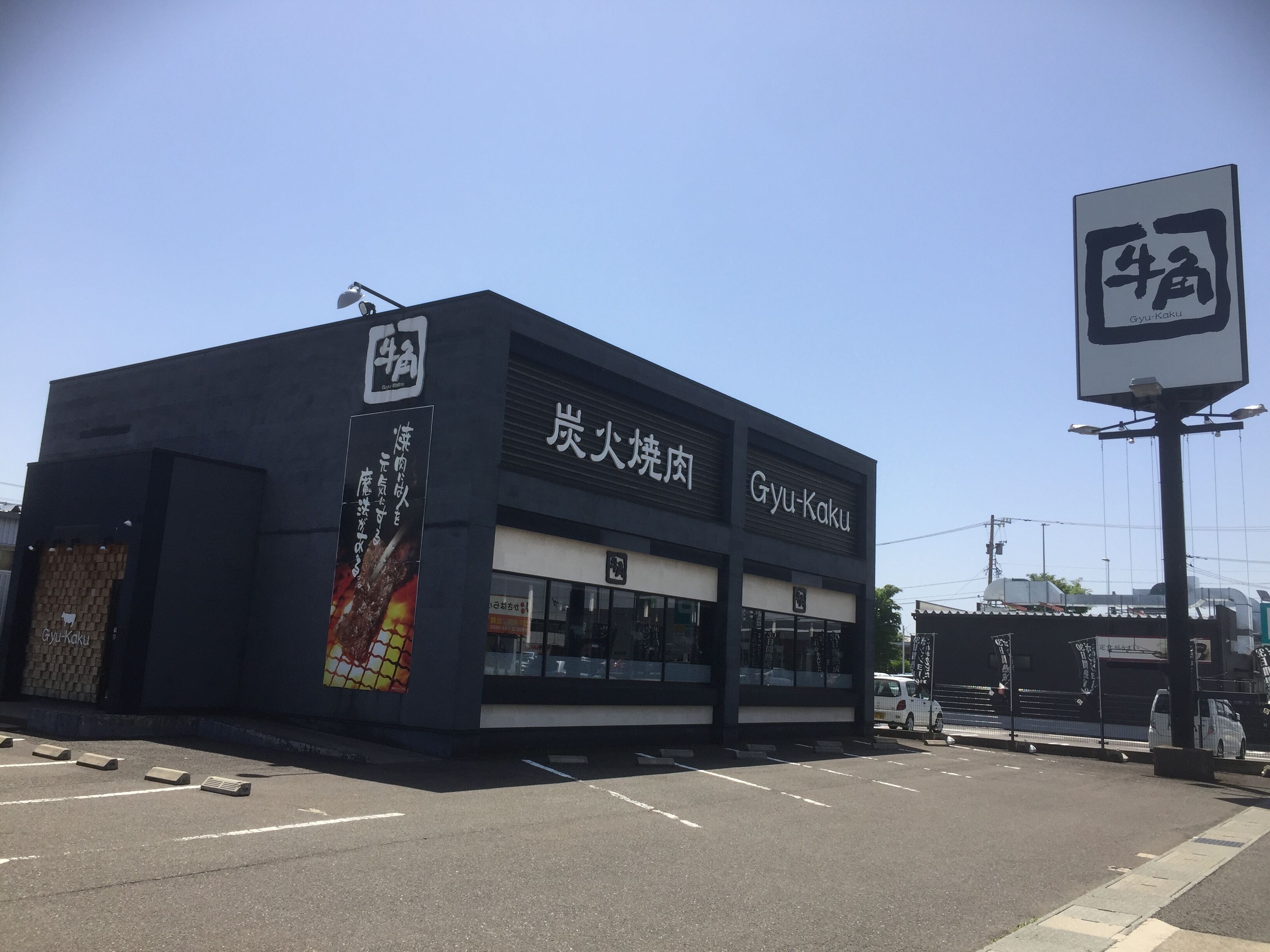 A modern building with a sign reading "Gyu-Kaku" and another sign with Chinese characters.