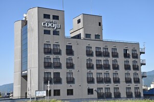 Um hotel moderno com vários andares, varandas e céu claro.
