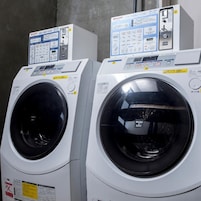 Two front-loading washing machines with control panels, placed side by side.