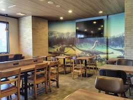 Um restaurante com paredes de tijolo, mesas e cadeiras de madeira.