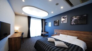 A hotel room with a large bed, a desk, a chair, a TV, and a ceiling light. - Hotel Cooju Fukui (Sakai)