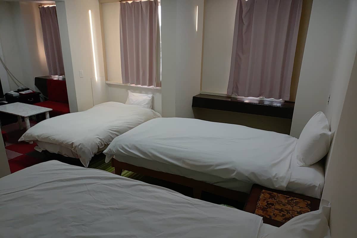Una habitación de hotel con dos camas individuales, un escritorio pequeño y una silla.