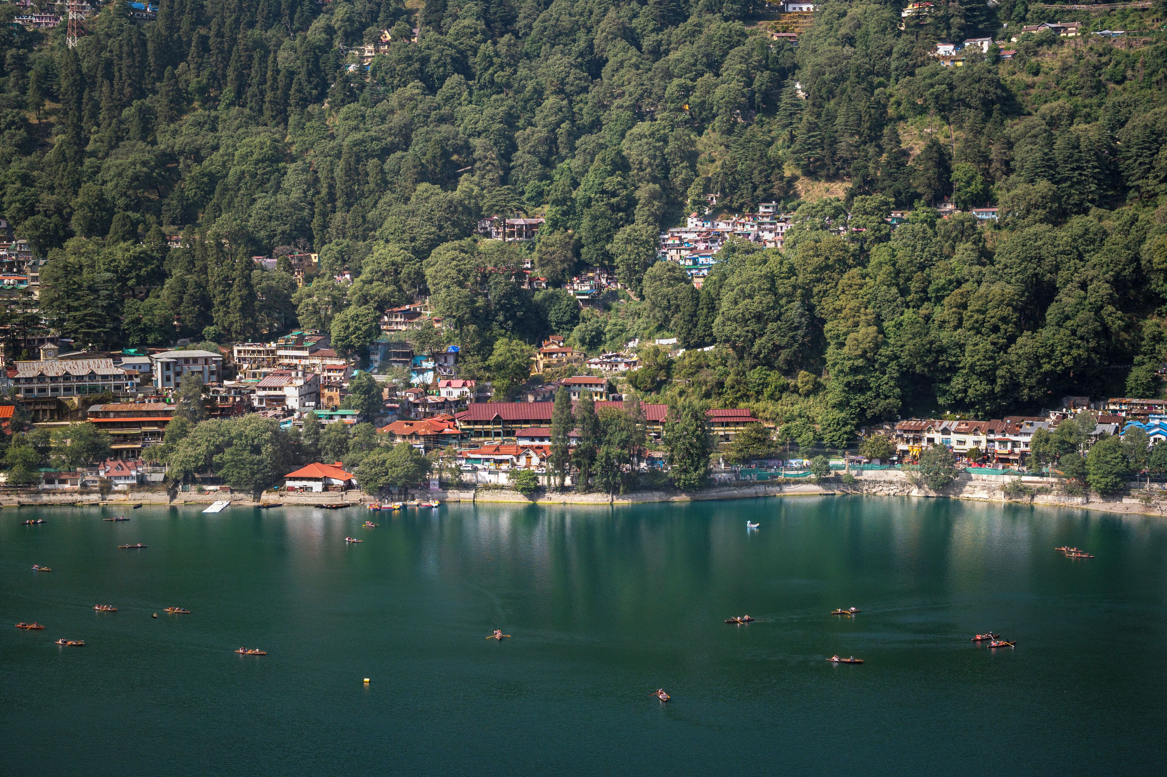 Un pueblo a orillas de un lago, con edificios a lo largo de la costa y barcos en el agua.