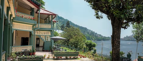 Un edificio con balcón, mobiliario exterior y vistas a un lago.