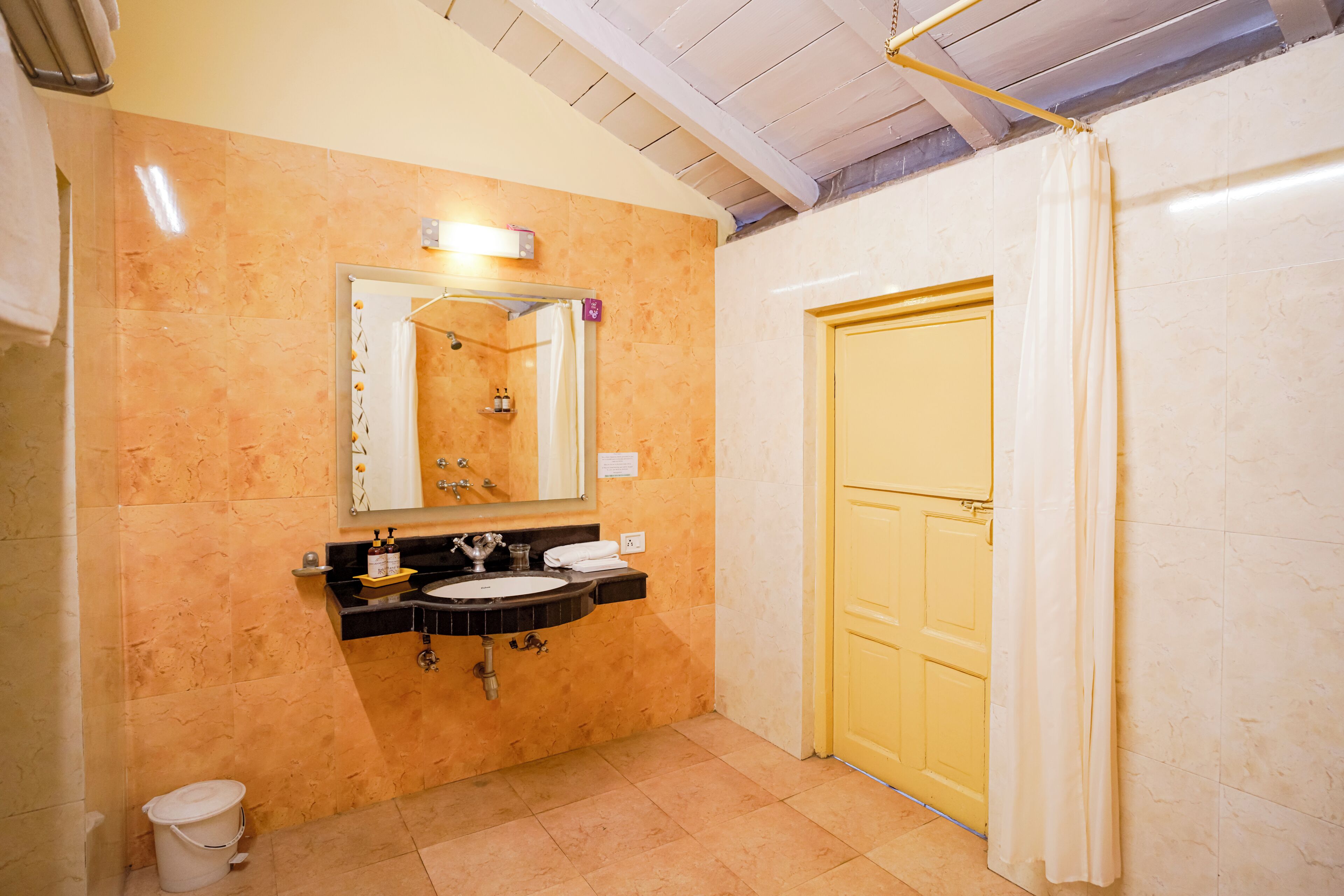 Un baño con lavamanos, espejo y cortina de ducha.