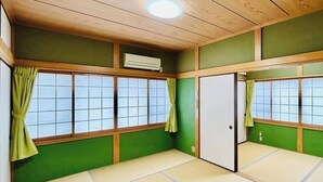 Una habitación japonesa tradicional con suelo de tatami, paneles shoji y una puerta corredera.