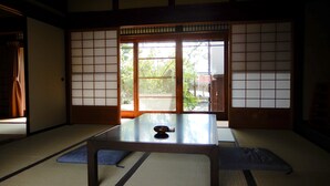 Een traditionele Japanse kamer met tatami vloerbedekking, een lage tafel en schuifdeuren met shoji schermen.