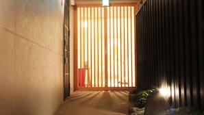 Ein schmaler Flur mit einer Holztür und einer schwarzen Wand.
