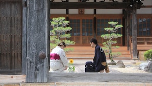 Ein traditionelles japanisches Gebäude mit Holzarchitektur und einem Steinweg.