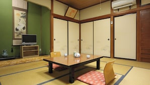 A traditional Japanese room with tatami flooring, a low table, and shoji screens. - Minshuku Sampo (Chichibu)