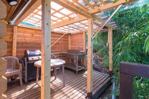 A wooden deck with a grill, table, chairs, and a small table with a sink. - Manazuru Glamping & BBQ Coottage Deja Vu (Manazuru)