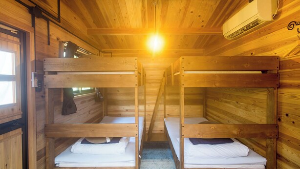 A cabin with wooden walls, bunk beds, a window, and an air conditioning unit. - Manazuru Glamping & BBQ Coottage Deja Vu (Manazuru)