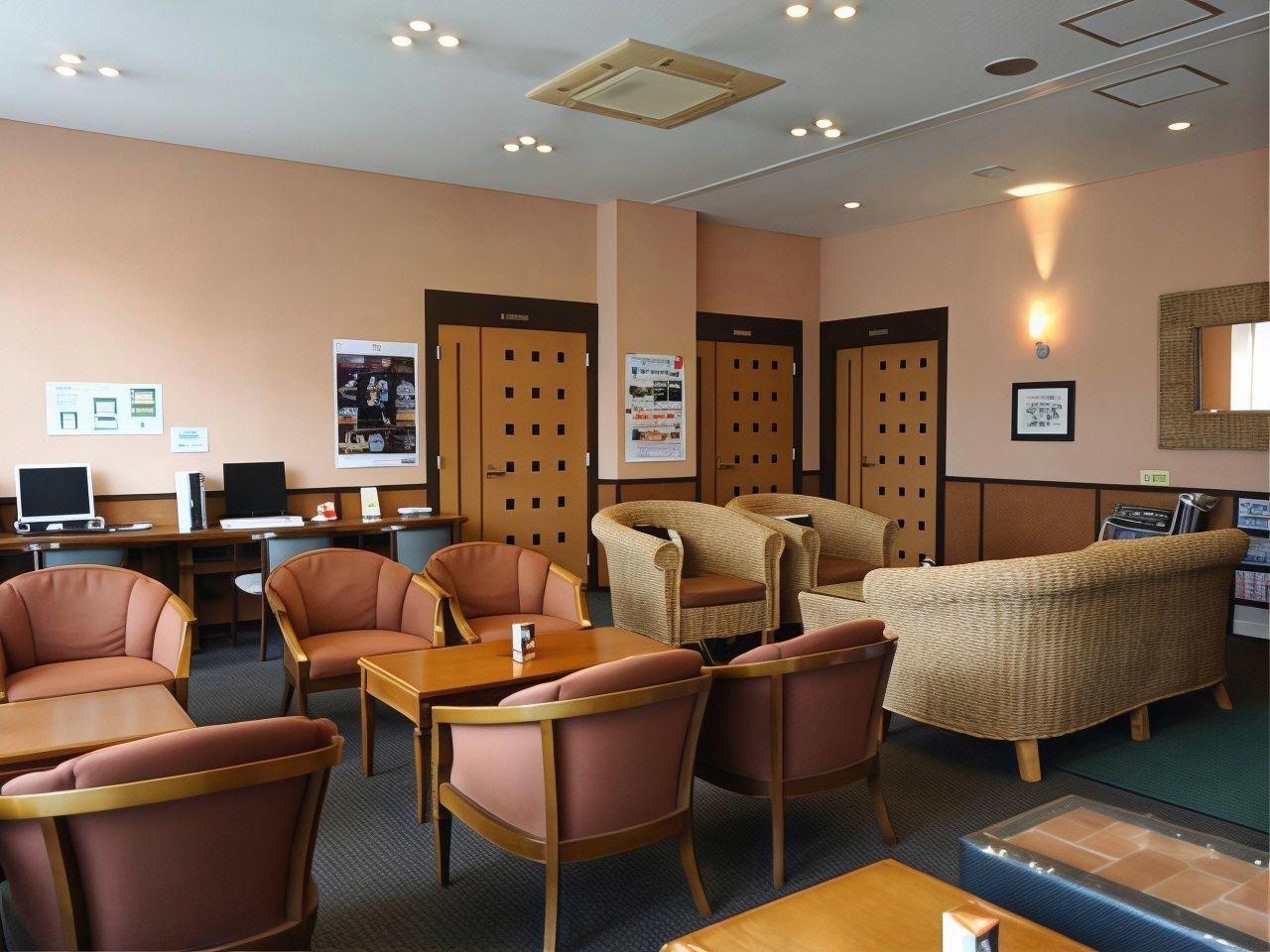 A hotel lobby with seating arrangements, a reception desk, and a wall-mounted information board.