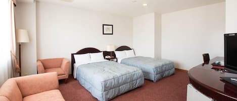 A hotel room with two beds, a desk, a chair, and a television.
