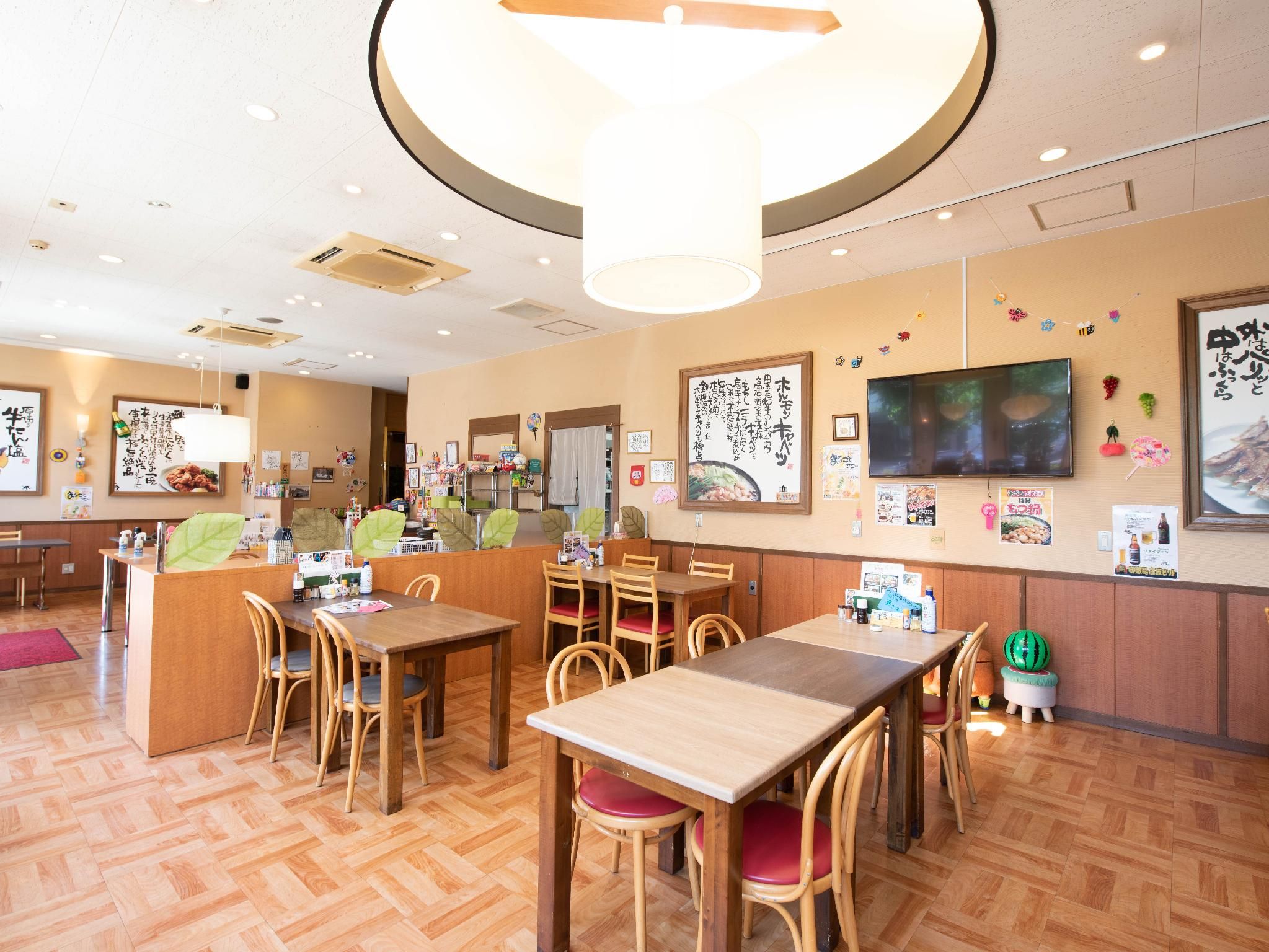A restaurant interior with wooden furniture, a central counter, and wall decorations.
