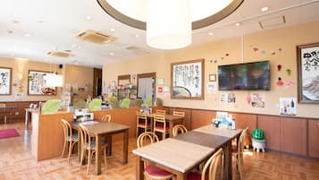 Un interior de restaurante con mobiliario de madera, una barra central y decoraciones en las paredes.