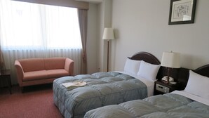 A hotel room with two beds, a sofa, a bedside table with a lamp, and a window with curtains. - Shizuoka Hotel Tokinosumika (Shizuoka)