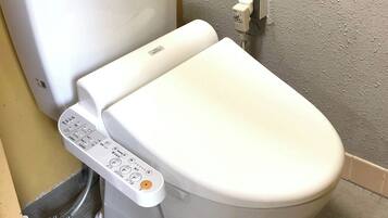 Un water con un pannello di controllo dotato di numerosi pulsanti e una leva per lo scarico.