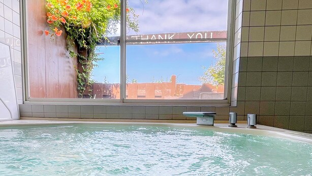 Wellnessbereich mit großem Fenster, Whirlpool und einem Schild mit der Aufschrift 'THANK YOU'.