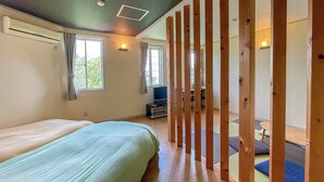 Ein Schlafzimmer mit Bett, Fernseher und Fenster.