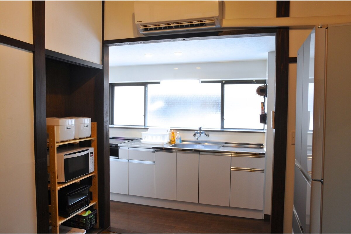 A modern kitchen with white cabinets, a stainless steel sink, and a window above the countertop.