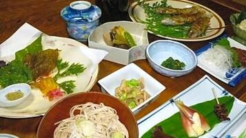 A variety of dishes on a table, including noodles, vegetables, and fish.