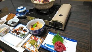 A table with various dishes, a portable stove, and a teapot. - Minshuku Yurika (Urugi)
