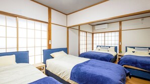 Een traditionele Japanse kamer met tatami vloerbedekking, shoji schermen en een futon bedopstelling.