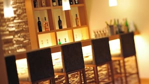 Eine Bar mit Holzsesseln und Regalen voller Spirituosenflaschen.