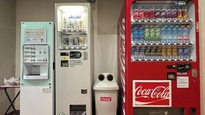 Three vending machines: a Coca-Cola machine, a Asahi machine, and a water dispenser.