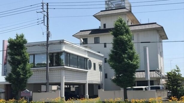A modern building with a flat roof and a small tower-like structure on top.