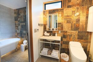 Un baño con bañera, inodoro y lavamanos.