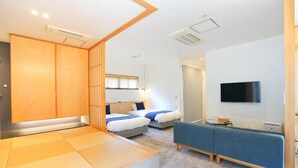 A modern hotel room with a bed, a sofa, a TV, and a sliding door. - Bise Nob's Village (Motobu)