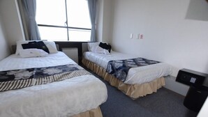A hotel room with two beds, a window with curtains, a bedside table, and a wall-mounted control panel. - Tsukuba View Hotel (Joso)