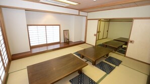 A traditional Japanese room with tatami flooring, low wooden tables, and sliding doors. - Tsukuba View Hotel (Joso)