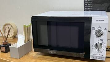 A microwave oven with a digital display, power settings, and a brand name.