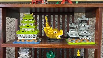 Una estantería de madera con varios modelos LEGO de pagodas y una estatua de Buda.