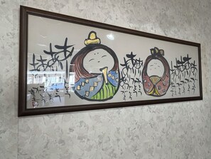 A framed artwork with abstract designs and calligraphy on a textured wall. - Hotel Tetora Kasugai Station Hotel (Kasugai)