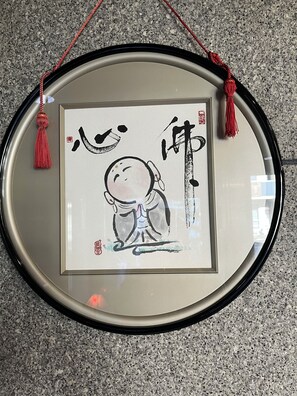 A framed artwork with calligraphy and a red tassel, hanging on a wall. - Hotel Tetora Kasugai Station Hotel (Kasugai)