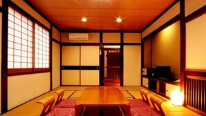 Ein traditioneller japanischer Raum mit Tatami-Matten, einem niedrigen Holztisch und Schiebetüren.