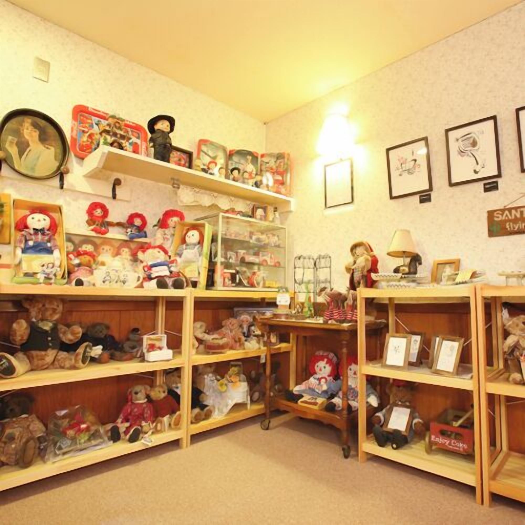 A room with wooden shelves filled with various stuffed toys and figurines.