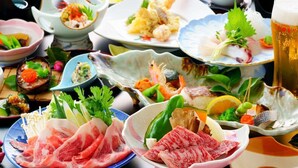 Une variété de plats, notamment des sashimis, des légumes, et un verre de bière, sont disposés sur une table.