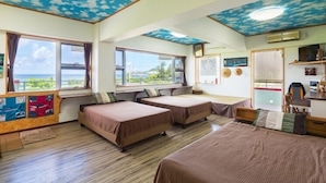 A room with two beds, a desk, and a view of the sea. - Pension Umi to Yama (Nago)